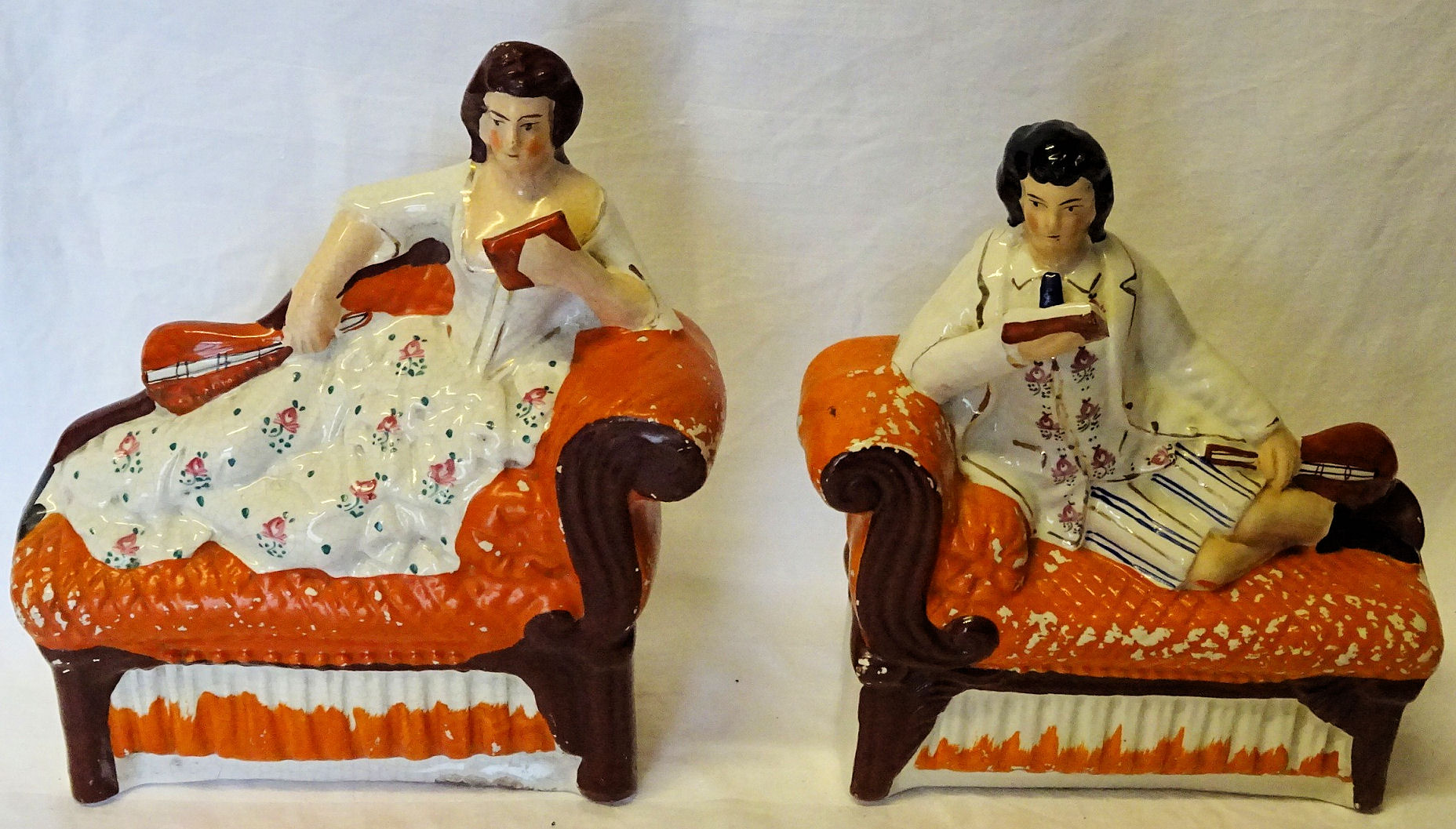 A pair of 19th Century Staffordshire pottery Figures of male and female musicians each reclining