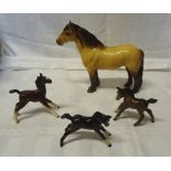 A Beswick Highland pony in dun gloss, No.1644, leg damaged and three Beswick foals.