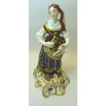 A 19th Century Continental standing female Figure playing a triangle, dress decorated in blue and