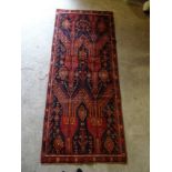 A Balouchi Rug of geometric and floral design on a blue field and bordered. 7' 4" (223cms) x 3'