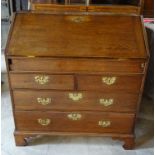 An 18th Century oak Bureau, the interior fitted with a well, small drawers, pigeon holes and