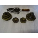 A number of brass Weights and an iron Trivet with turned wooden handle.