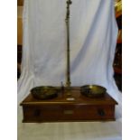 A set of brass Balance Scales by Day & Millward of Birmingham on a single drawer wooden stand,