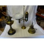A brass table Oil Lamp on an adjustable column and two other lamps.