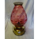 A brass Oil Lamp with a large dimpled cranberry glass shade. 19" (49cms) high.