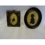 A 19th century Miniature oval Portrait of a boy wearing a black coat in an iron and brass frame, the