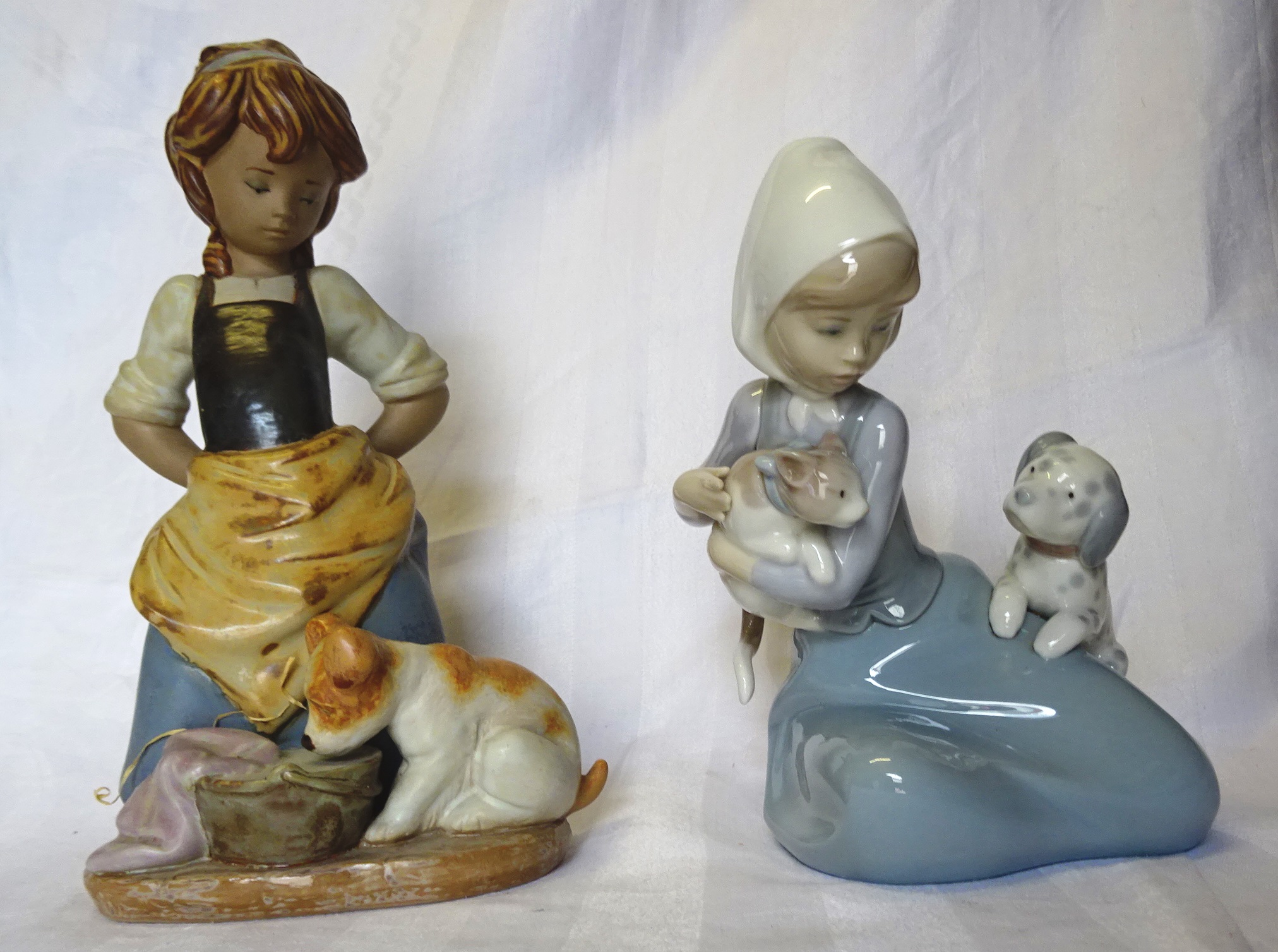 A Lladro matt Figure of a girl with a puppy, and another Lladro Figure of a girl with two puppies.