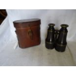 A pair of leather covered Military Binoculars in a leather case.