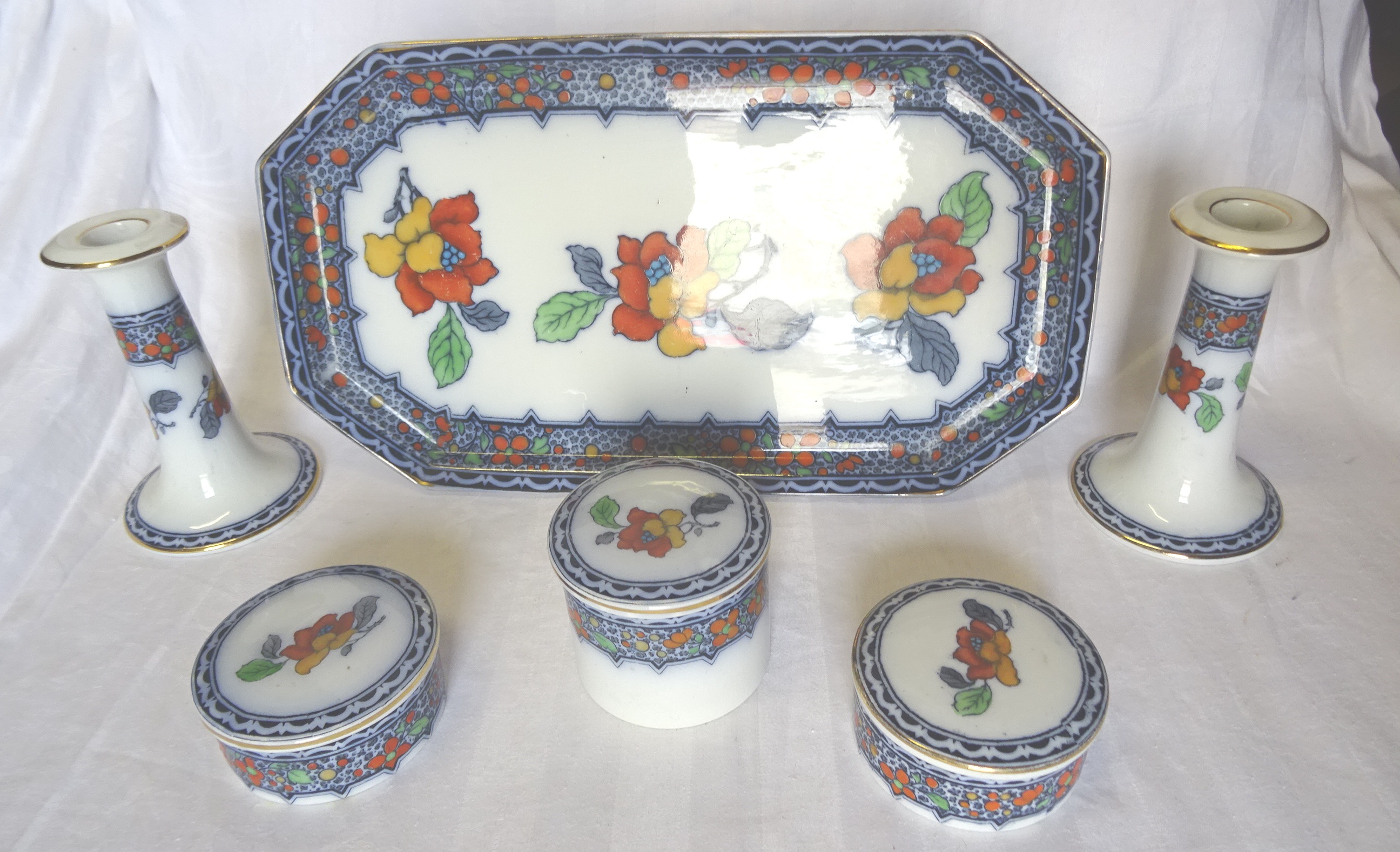 A Keeling & Co six piece Dressing Table Set decorated with flowers in orange, red, blue, etc.,