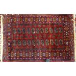 An Afghan Bokhara Rug of traditional elephant's foot design on a red field and bordered, 4' 3" (