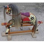 A dapple grey Rocking Horse with saddle and harness, on a wooden stand, 3' 9" (150cms) long.