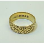 An engraved 18ct. gold Wedding Band. (4.8gms).