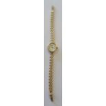 A ladies Rotary quartz Wristwatch with oval white dial, Roman numerals in a 9ct. gold case on a gold