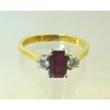 An 18ct. gold Ring set with an emerald cut ruby and two diamonds.