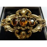 A Victorian Brooch of scroll design with three amber coloured stones.