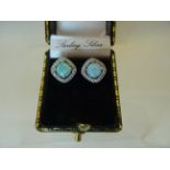 A pair of silver Earrings set with opals and cubic zirconia.