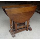 A Georgian design oak Cottage Dining Table with 'D' shape drop leaves and gated supports, on splay