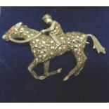 A silver and marcasite Brooch in the form of a racehorse and jockey.