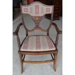 An Edwardian mahogany frame Elbow Chair with inlaid decoration, upholstered seat and splay supports.