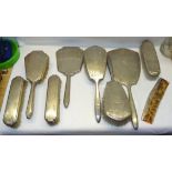 An engine turned silver backed five piece Dressing Table Set initialled 'J' and a four piece