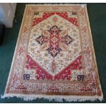 A Heriz pattern Rug with a geometric centre medallion on a beige and red floral field and