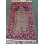 An Indian Prayer Rug with Mihrab panel on a green field and bordered. 4' 10" (148cms) x 3' (92cms).