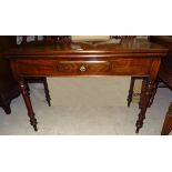 A Victorian mahogany Tea Table with fold over oblong top, dummy frieze drawer and turned supports.