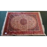 A Keshan pattern Rug with a centre floral medallion on a beige field and bordered. 6' 3" (190cms)