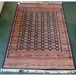 A Bokhara Rug of traditional design on a blue field and multi stripe border. 7' 6" (230cms) x 5' (