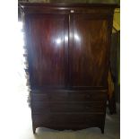 An early Victorian mahogany Linen Press, the upper section fitted with sliding trays and enclosed by