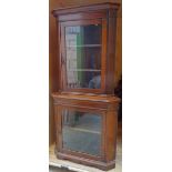 An early 20th Century oak Corner Cabinet, the upper section enclosed by a clear glass door with