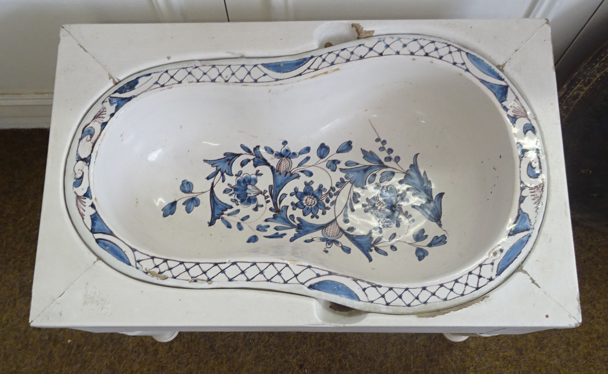 A French Faience Bidet Liner decorated in blue and white with trailing leaves and flowers, the