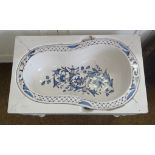 A French Faience Bidet Liner decorated in blue and white with trailing leaves and flowers, the