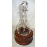 A Cumbria Crystal glass Decanter with rounded bottom in a wooden stand, boxed.