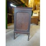 An Edwardian mahogany Sheet Music Cabinet with blind fret carved decoration, enclosed by a single