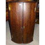 A George III oak bow fronted Corner Cupboard enclosed by a pair of panel doors. 2' (61cms) wide.