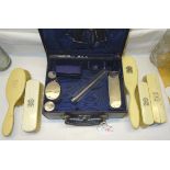 A small leather Toilet Case containing four silver mounted glass jars, silver hairbrush etc. London,