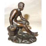 AFTER THE ANTIQUE; a small bronze of a naked male seated on a rock, 4" (10cms) high.
