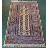 An Afghan Bokhara Rug of traditional elephants foot design on a beige field and boarded. 5' 8" (