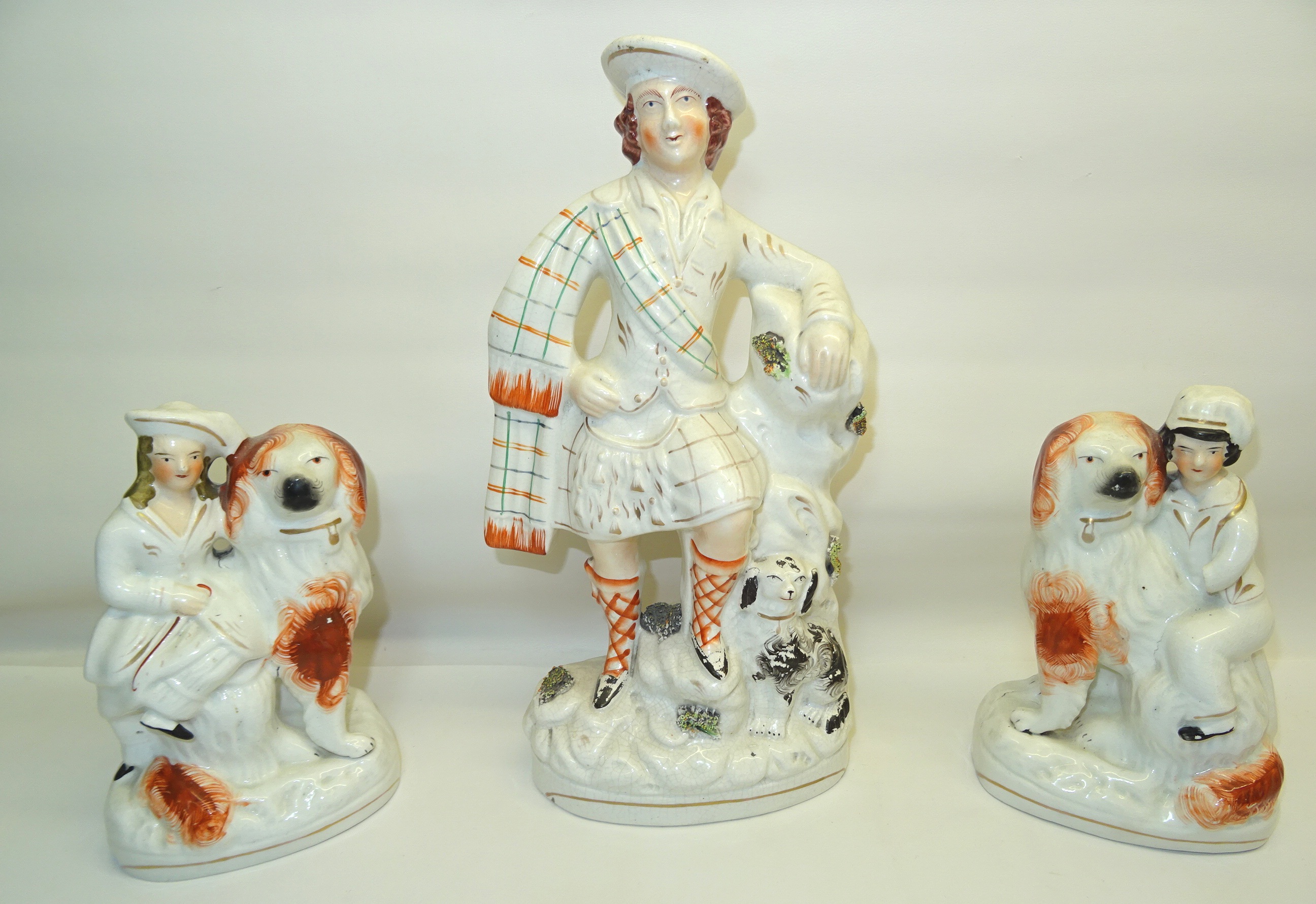 A pair of Staffordshire pottery Mantel Ornaments in the form of children with King Charles Spaniels,