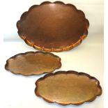 A pair of Newlyn design Arts & Crafts oval shallow Trays engraved with fish and with crimped rims,