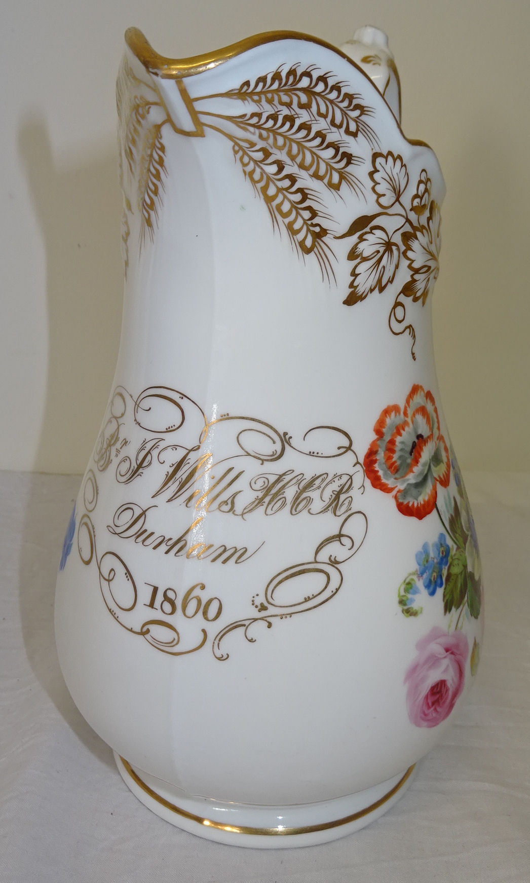 A 19th century Davenport Jug painted with a spray of flowers within a moulded gilt border and - Image 2 of 2