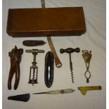 A leather Box and Contents including two fleams, metal skirt hem lifter, wooden nut crackers