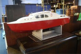 A model boat with red hull.