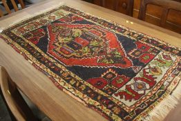 A small Persian design rug. 100 cm x 55 cm