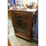 A Victorian walnut cabinet with glazed door.