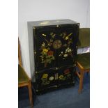 An Oriental black lacquered and painted cabinet.