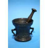 A bronze pestle and mortar.