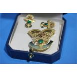 An Aztec design emerald 18ct brooch and earrings, 11grms.