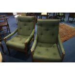 A pair of Guy Rogers style teak armchairs, with padded backs, arms and seats.